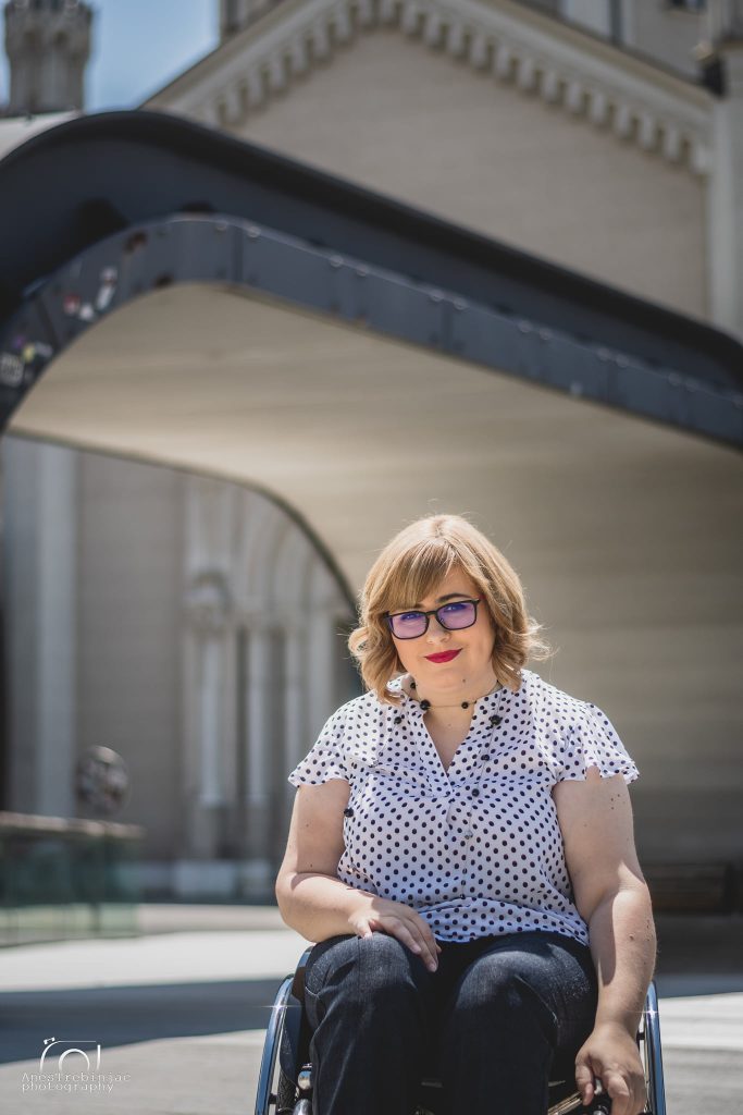 Žena u invalidskim kolicima ispod arkada stare zgrade